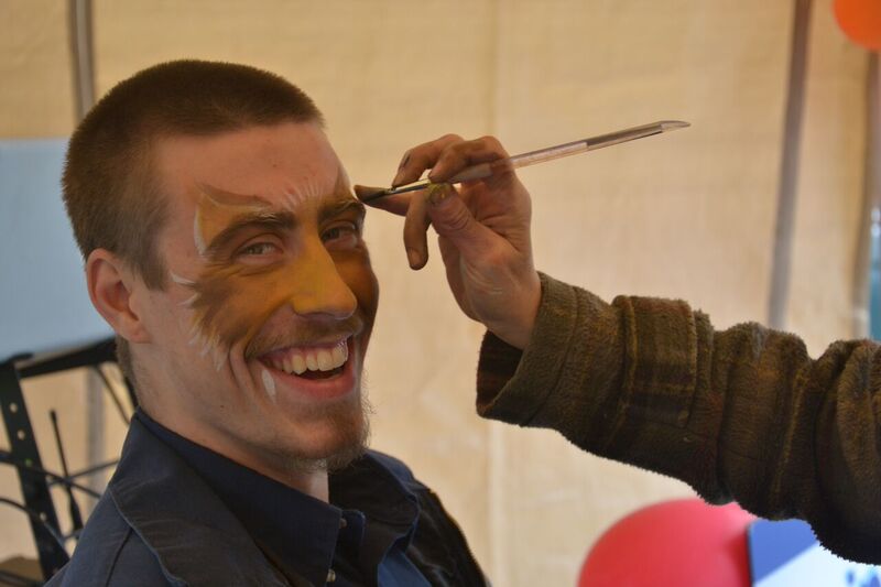 Smiling client gets his face painted
